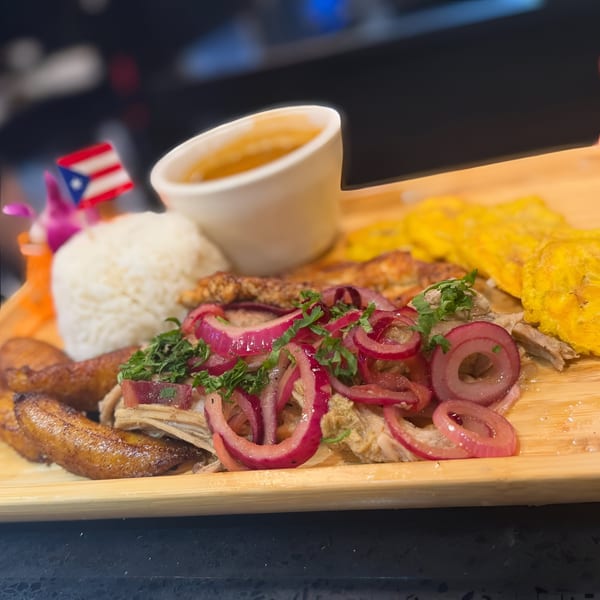 Dominican dish with rice, fried plantains, meat, red onions, and a dipping sauce.